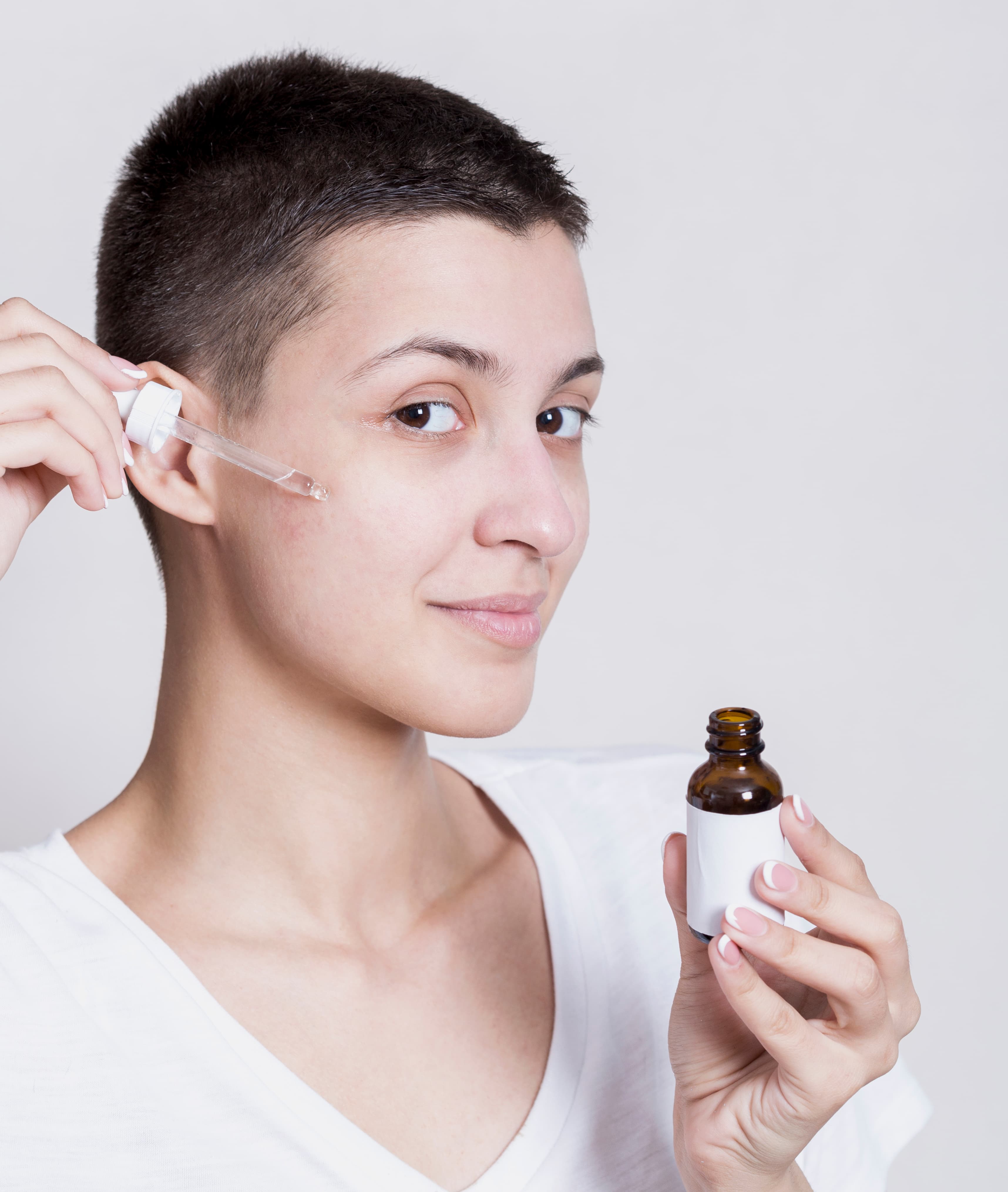 Woman applying serum to face